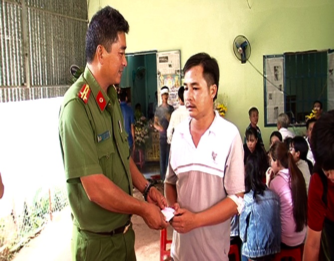 Thượng tá Đặng Ngọc Hùng, Phó trưởng công an huyện, thanh viên Ban ATGT huyện trao số tiền hỗ trợ cho gia đình anh Kánh