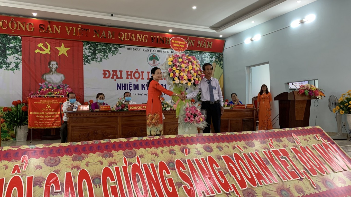 Chủ tịch Hội người cao tuổi tỉnh Bình Phước Nguyễn Công Sởi (bìa trái) tặng hoa chúc mừng đại hội.